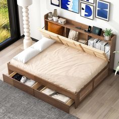 a bed with drawers underneath it and pictures on the wall