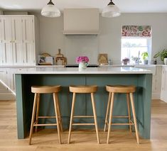 two wooden stools sit at the center of a kitchen island