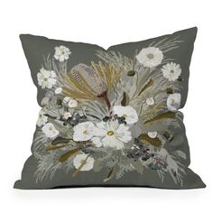 a gray pillow with white flowers and feathers on the front, sitting on a white surface