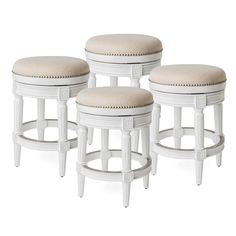 three white stools with beige upholstered cushions