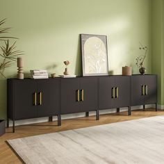 a living room with green walls and white rugs on the wooden floor next to a black cabinet