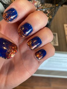 Blue polish with orange glitter ombre Navy And Orange Nails Design, Navy Orange Nails, Blue Thanksgiving Nails, Navy Blue And Burnt Orange Nails, Burnt Orange And Blue Nails, Blue And Orange Fall Nails, Navy Blue Orange Nails, Blue And Orange Ombre Nails, Dark Blue And Orange Nails