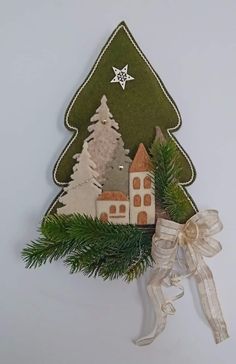 an ornament is hanging on the wall next to a christmas tree and house