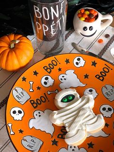 a plate that has some kind of ghost cookie on it with candy in the background