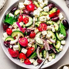 a salad with cucumbers, tomatoes, onions and feta cheese in a bowl