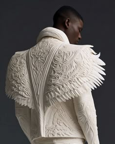 the back of a man's white jacket with wings on his shoulders and arms