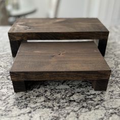 a wooden step stool sitting on top of a marble counter