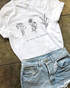 a white t - shirt and jean shorts with flowers on it, sitting next to each other