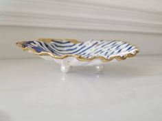 a blue and white striped bowl sitting on top of a table next to a wall