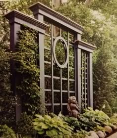 an old photo of a garden gate surrounded by greenery