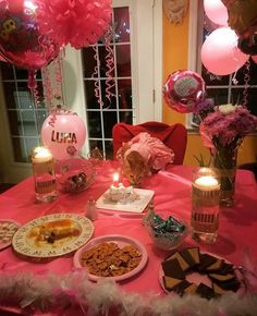 a table set up for a birthday party with balloons, cookies and desserts on it