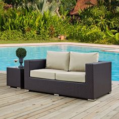 an outdoor couch sitting on top of a wooden deck next to a swimming pool