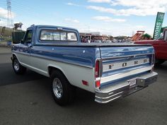 an older pickup truck parked in a parking lot