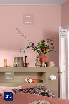 a bedroom with pink walls and flowers in vases