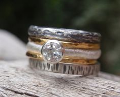 three different rings are stacked on top of each other with a diamond in the center