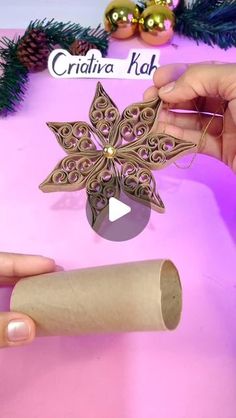 someone is making a paper snowflake ornament out of toilet paper roll