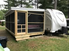 a small trailer is parked in the grass