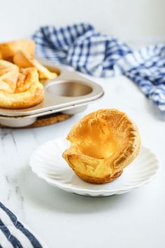 two plates with pastries on them sitting on a table next to muffin tins