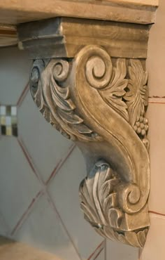 the corner of a wall with an ornate design on it's side and tile back splash