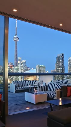 a living room filled with furniture next to a large window overlooking a cityscape