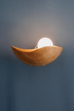 a light that is sitting on top of a wooden object in the dark blue room