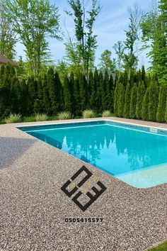 an empty swimming pool surrounded by trees and bushes