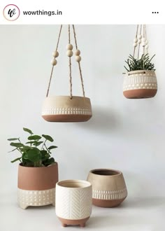 three hanging planters with plants in them, one is white and the other has brown