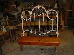 a white iron bed frame sitting in a room next to other furniture and tools on the floor