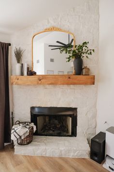 a living room with a fire place and a mirror on the wall above it's mantle