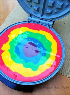 a waffle iron with colorful paint on it