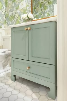 a bathroom with a green cabinet and white toilet