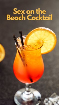 a close up of a drink in a glass on a table with an orange slice