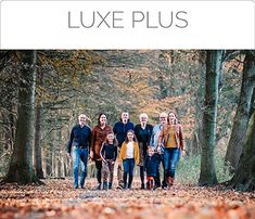 a group of people standing in the middle of a forest with leaves on the ground