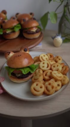 a plate with some hamburgers and pretzels on it next to other food items