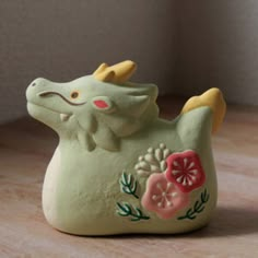 a ceramic figurine of an elephant with flowers on it