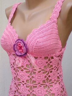 a mannequin wearing a pink crochet swimsuit with a flower on it