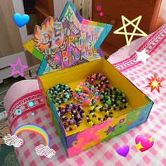 an open box on a pink and white checkered tablecloth with balloons in the background