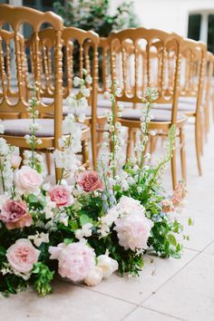 wedding chairs with flowers and greenery on the floor