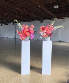 two white vases with pink and orange flowers in them