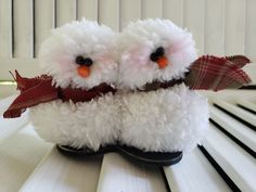 two white stuffed animals sitting on top of a wooden table