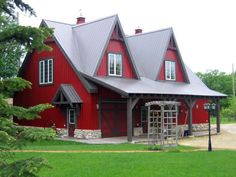 a large red house sitting on top of a lush green field