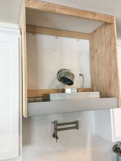 an open shelf above a sink in a kitchen