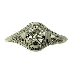 an antique style diamond ring with filigrees