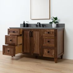 a bathroom vanity with two drawers and a mirror on the wall above it is shown