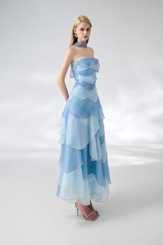 The dress is expertly designed with a classic straight neck and layered organza material, creating an elegant ankle-length silhouette. Perfect for formal occasions, this dress exudes sophistication and timeless style. *Product length is measured from the shoulder to the hem. Ethereal Dress Blue, Something Blue Outfit, Organza Dress Styles, Gown Neck Design, Blue Gowns Elegant, Light Blue Outfit Ideas, Prom Blue Dress, Light Blue Party Dress, Shaded Dress