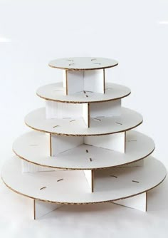 a three tiered cake stand with white plates stacked on each other and gold trim around the edges