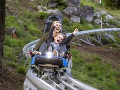 two people on a roller coaster with their faces covered by fake hair and one is screaming