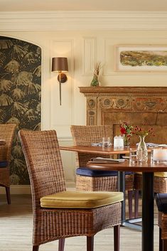 a dining room table with chairs and a fire place in the background at a restaurant