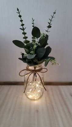 a mason jar filled with greenery and lights