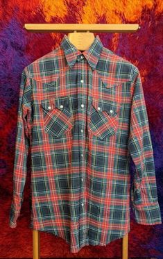 "✰ 70s Western shirt at it's finest ✰ classic tartan plaid ✰ Beautiful pearl snaps ✰ Thicker cotton  Circa: 1970s Material: cotton Label: DEE CEE, made in USA - MEASUREMENTS- (measurements taken flat) please refer to listing images for how we measure Label size: 15.5/33 Length: 30\" Shoulder: 18\" Chest: 21.5\" Hem: 21.5\" (unfinished) Sleeve: 24\" Condition:  Beautiful, like new condition *for more listings, please click here: https://www.etsy.com/shop/MonarkVintage Vintage condition usually me Retro Cotton Flannel Shirt For Fall, Retro Long Sleeve Plaid Shirt, Fitted Plaid Shirt For Winter, Retro Plaid Button-up Flannel Shirt, Retro Plaid Flannel Shirt For Fall, Retro Plaid Shirt For Fall, Vintage Plaid Cotton Flannel Shirt, Retro Button-up Flannel Shirt, Vintage Flannel Top With Button Closure